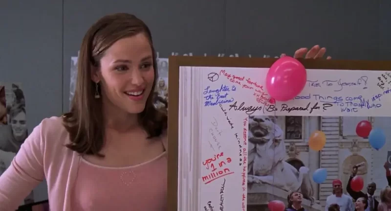a imagem mostra uma das cenas do filme de repente 30 com a protagonista segurando seu projeto para apresentar no trabalho